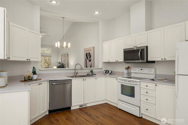 kitchen with visible vents, a sink, stainless steel appliances, white cabinetry, and a notable chandelier