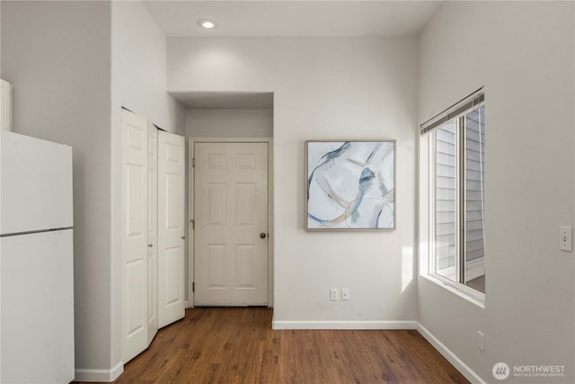 interior space featuring a wealth of natural light, baseboards, and wood finished floors