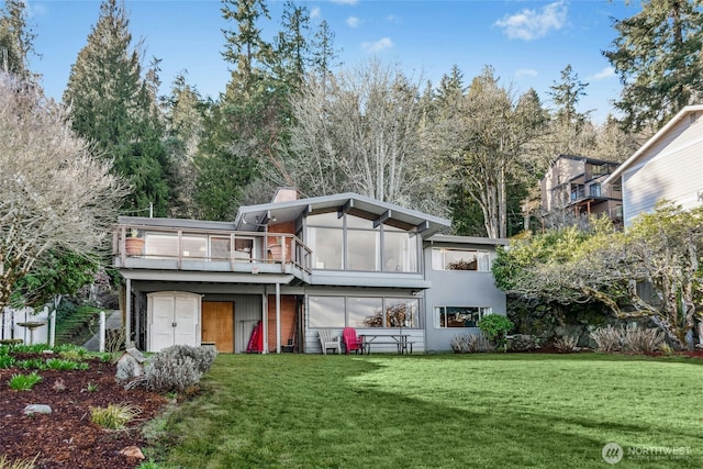 rear view of property featuring a wooden deck, a lawn, and a chimney