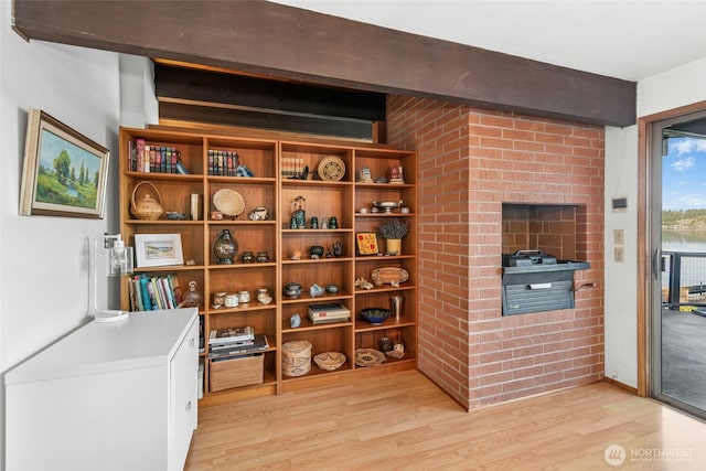 wine room featuring beamed ceiling and light wood-type flooring