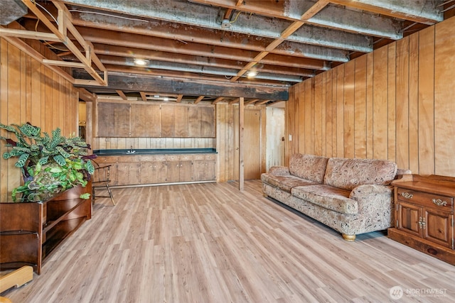 living area featuring wooden walls and wood finished floors