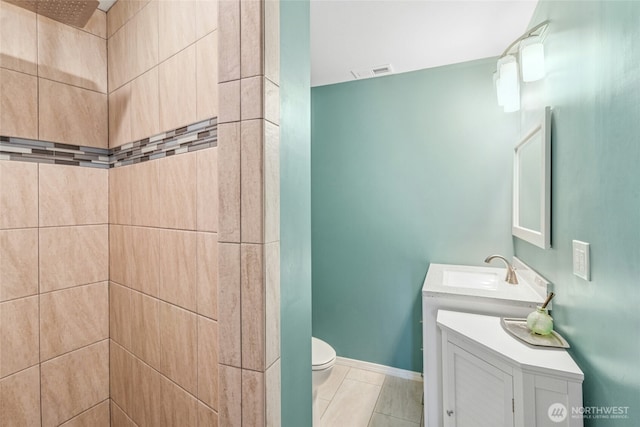 full bathroom with vanity, baseboards, visible vents, tiled shower, and toilet