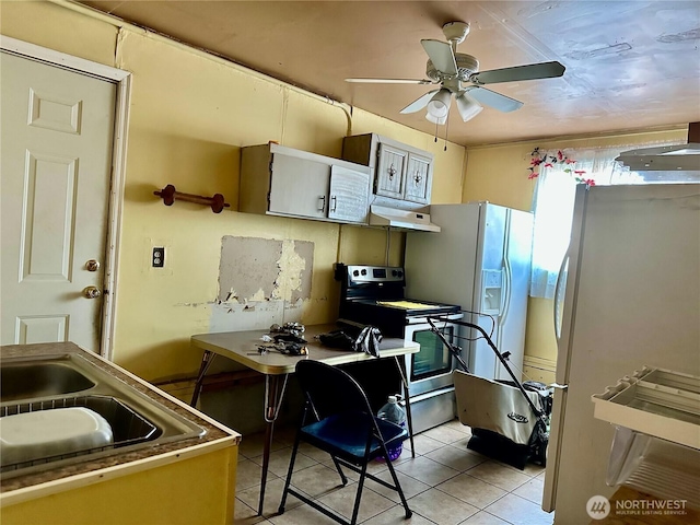 kitchen featuring light tile patterned floors, stainless steel electric stove, a ceiling fan, freestanding refrigerator, and under cabinet range hood