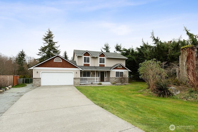 traditional home with a porch, fence, concrete driveway, a front yard, and a garage