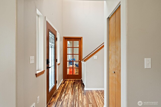 foyer entrance featuring baseboards and wood finished floors