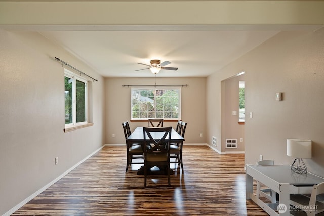 dining room featuring visible vents, ceiling fan, baseboards, and wood finished floors