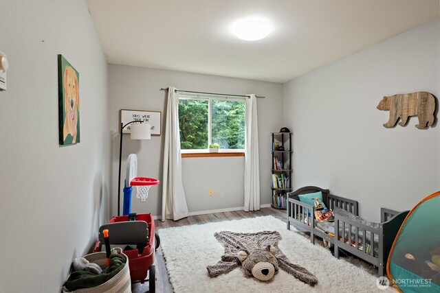 game room with baseboards and wood finished floors