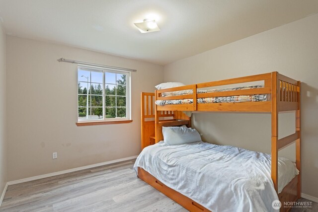 bedroom with baseboards and wood finished floors