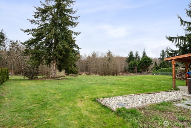 view of yard with a view of trees and fence