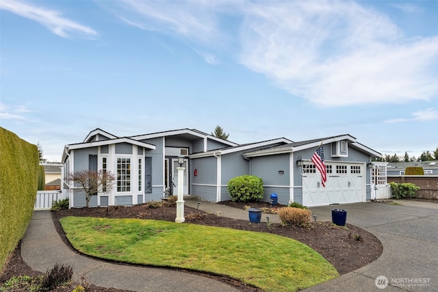 view of front of house featuring an attached garage, fence, and driveway