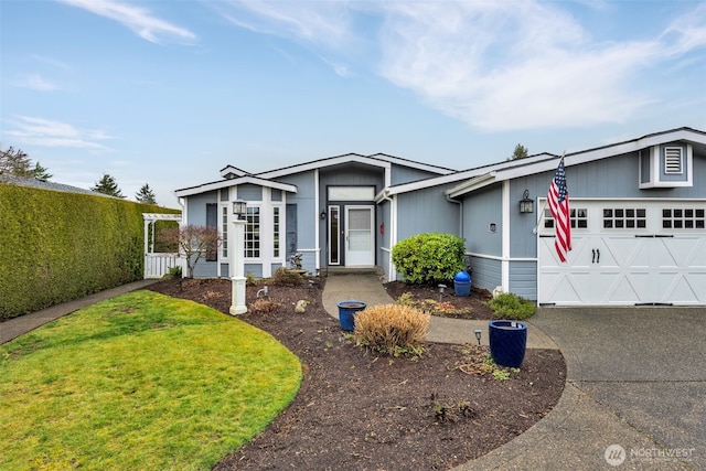 view of front of property with driveway, a front yard, and a garage