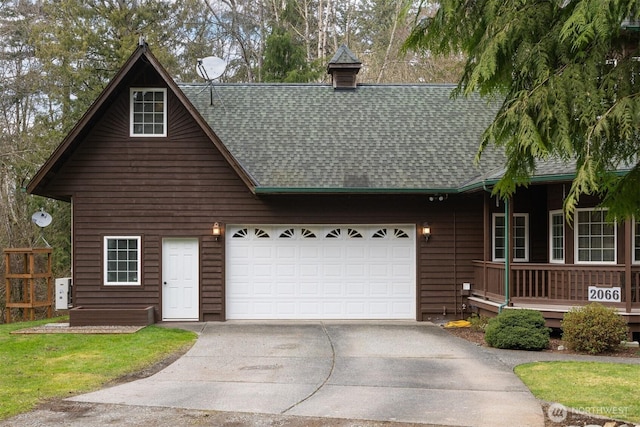 view of front of house featuring an attached garage, driveway, and a shingled roof