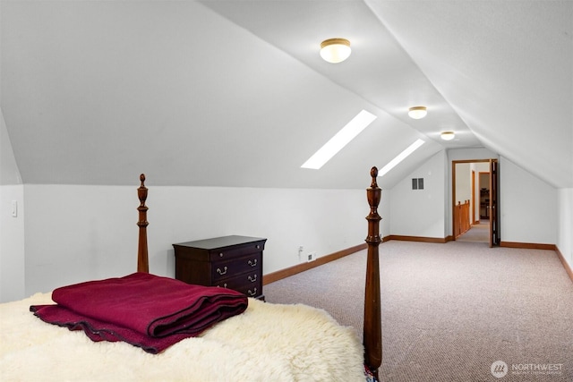 bedroom with visible vents, baseboards, carpet floors, and lofted ceiling with skylight