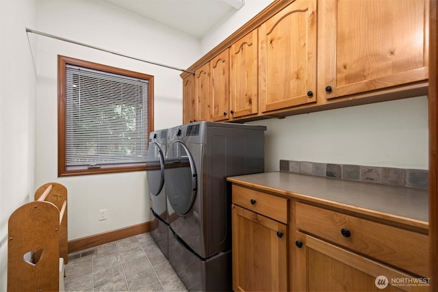 laundry room featuring visible vents, cabinet space, light tile patterned floors, baseboards, and washing machine and clothes dryer