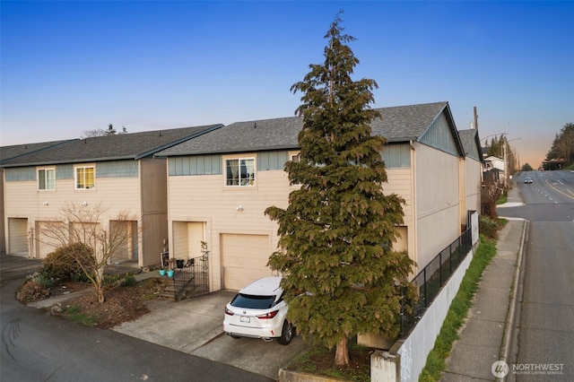 view of front of house with driveway, a shingled roof, and an attached garage