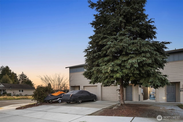 obstructed view of property with a garage and concrete driveway