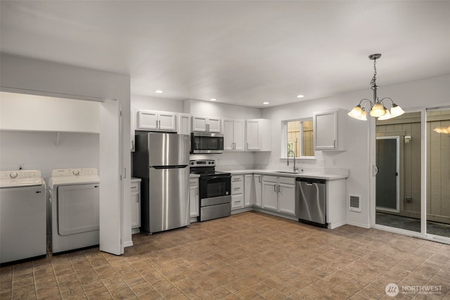 kitchen featuring appliances with stainless steel finishes, independent washer and dryer, light countertops, a sink, and recessed lighting