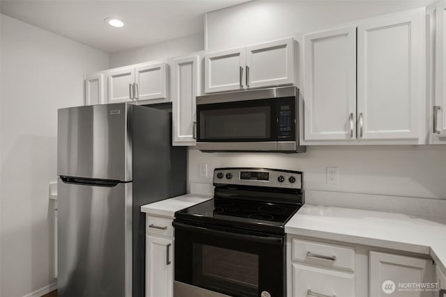 kitchen with appliances with stainless steel finishes, light countertops, white cabinets, and recessed lighting