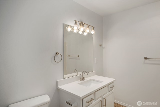 half bathroom featuring baseboards, vanity, and toilet