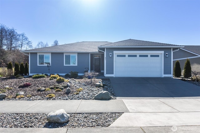 ranch-style house featuring concrete driveway and an attached garage