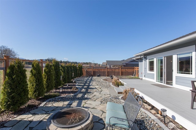 view of patio / terrace featuring a deck, an outdoor fire pit, and a fenced backyard