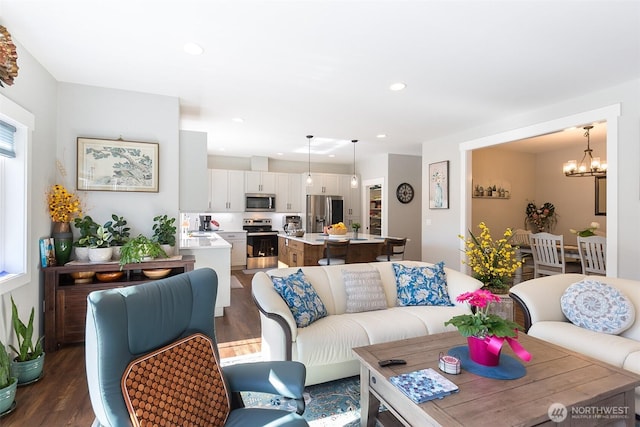 living area featuring dark wood-style flooring, an inviting chandelier, and recessed lighting