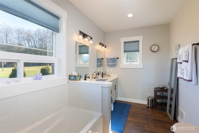 bathroom featuring a healthy amount of sunlight, visible vents, a sink, and wood finished floors