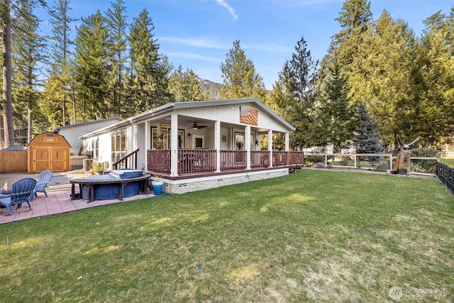 rear view of property featuring a ceiling fan, a patio, a fenced backyard, a storage shed, and an outdoor structure