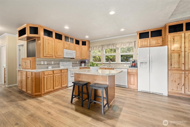 kitchen featuring white appliances, a kitchen island, light wood-style flooring, and crown molding