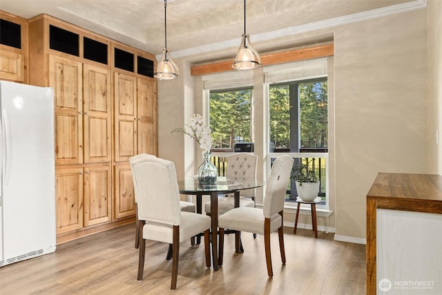 dining area with light wood-type flooring and baseboards