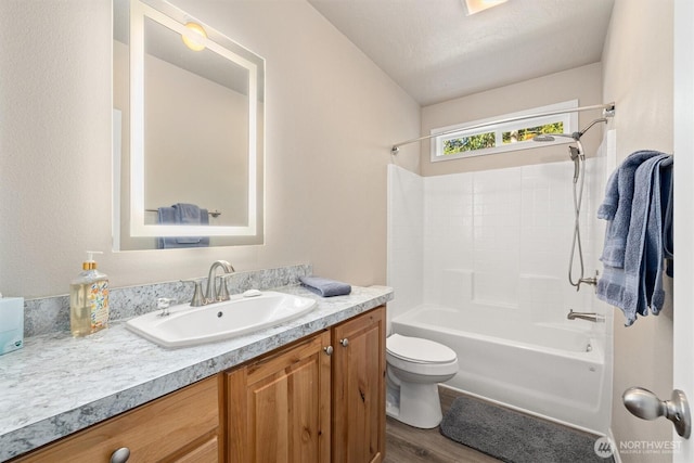 bathroom featuring shower / bathing tub combination, toilet, wood finished floors, and vanity