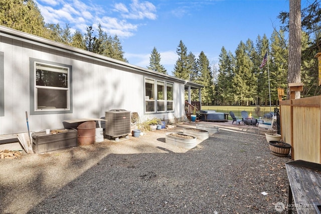 exterior space featuring a patio, a fire pit, central AC unit, and fence