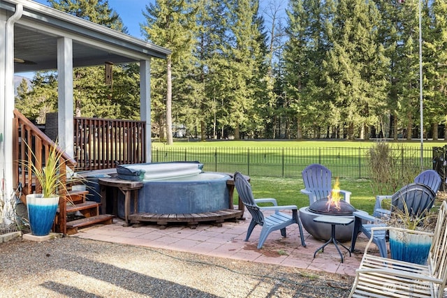 view of patio with an outdoor fire pit, a fenced backyard, and a hot tub