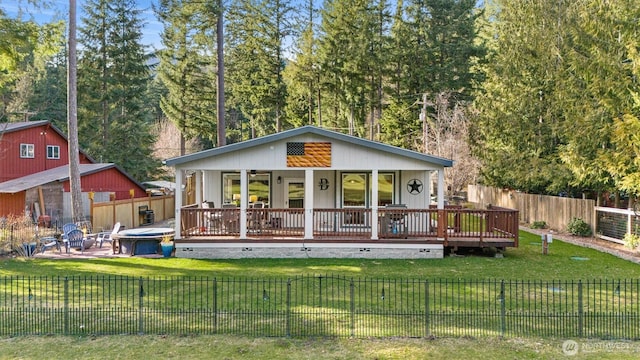 rear view of house featuring ceiling fan, a yard, a deck, and a fenced backyard