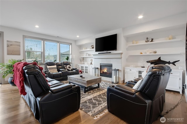 living room with a fireplace, wood finished floors, and recessed lighting