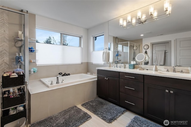 bathroom featuring a garden tub, double vanity, a stall shower, and a sink