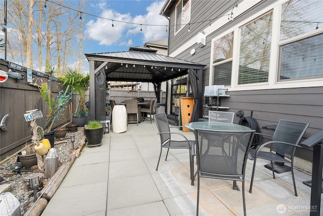 view of patio / terrace with a gazebo, outdoor dining area, and fence