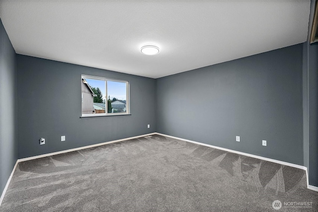 spare room with baseboards and carpet flooring