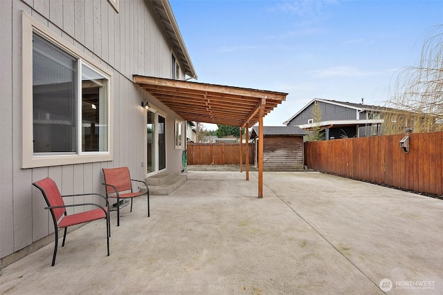 view of patio featuring a fenced backyard, an outdoor structure, and a storage shed