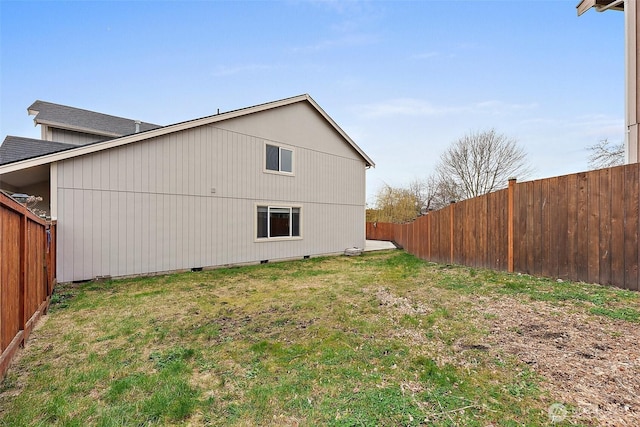 view of home's exterior with crawl space, a fenced backyard, and a lawn