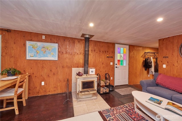 living room with recessed lighting, wooden walls, and a wood stove