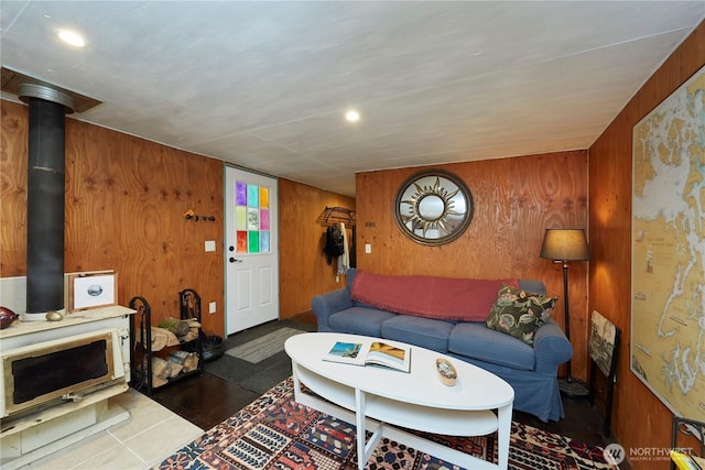 living room featuring recessed lighting, wood walls, and a wood stove