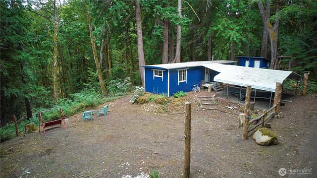 view of front facade with a view of trees and an outdoor structure