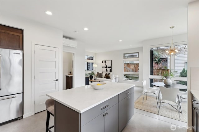 kitchen with recessed lighting, light countertops, freestanding refrigerator, and a wall unit AC