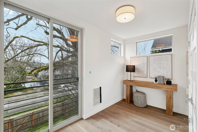 office space featuring wood finished floors, visible vents, and baseboards