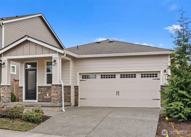 craftsman house with roof with shingles, an attached garage, covered porch, concrete driveway, and board and batten siding