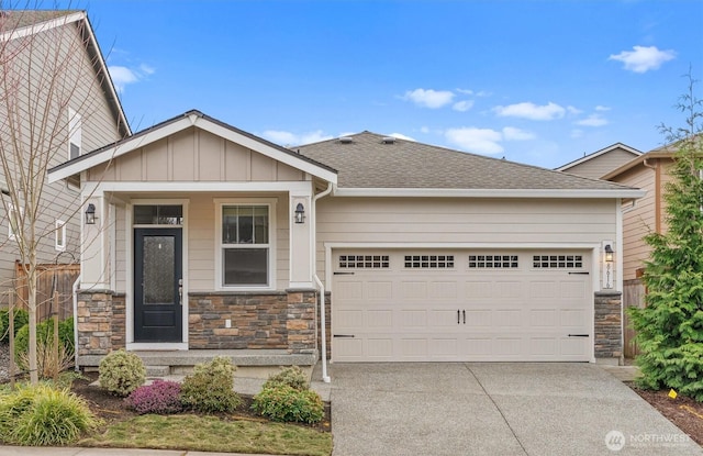 view of front of home featuring stone siding, an attached garage, board and batten siding, and driveway