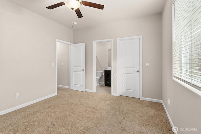 unfurnished bedroom with ceiling fan, baseboards, ensuite bathroom, and light carpet