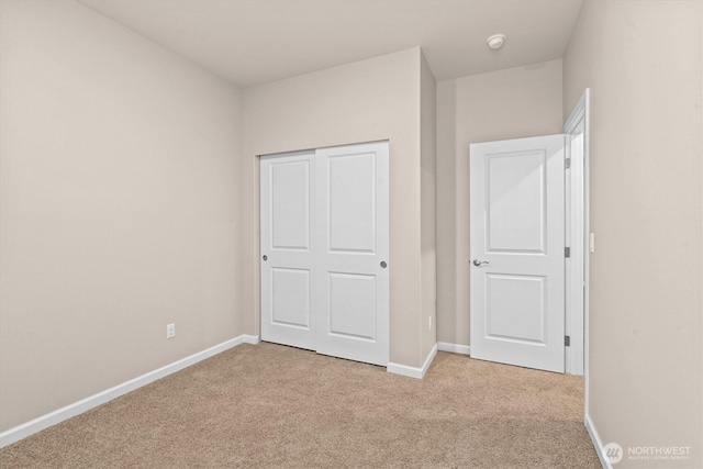 unfurnished bedroom with a closet, baseboards, and carpet flooring