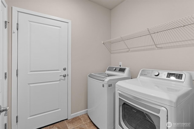 washroom with laundry area, washer and dryer, and baseboards